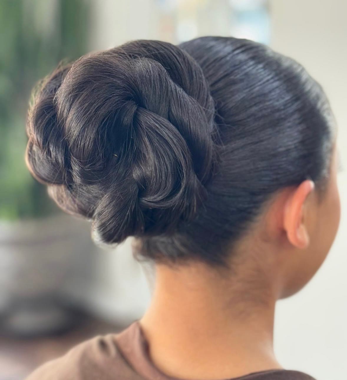 Glossy twisted rose bun updo on dark hair